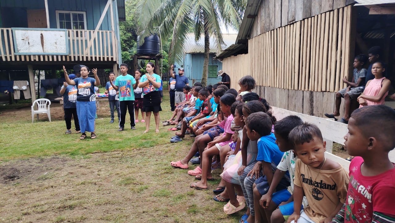 Children and adults gathered outdoors in a photo from Greg Crandell’s Honduras fundraiser