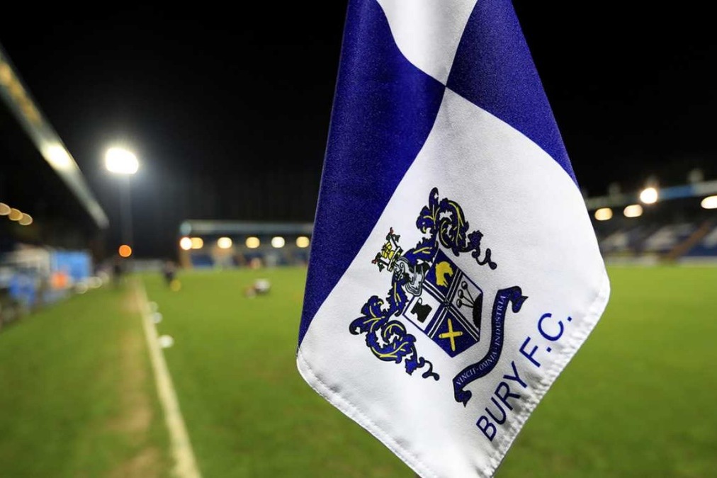 A picture of the Bury FC crest on a corner flag overlooking Gigg Lane, their stadium.